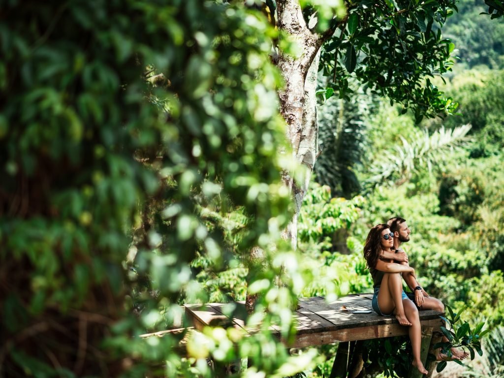 Couple among the greenery. A couple in love in the tropics. The couple is traveling in Asia. Beautiful couple traveling on the island of Bali. Man and woman on the background of nature. Copy space